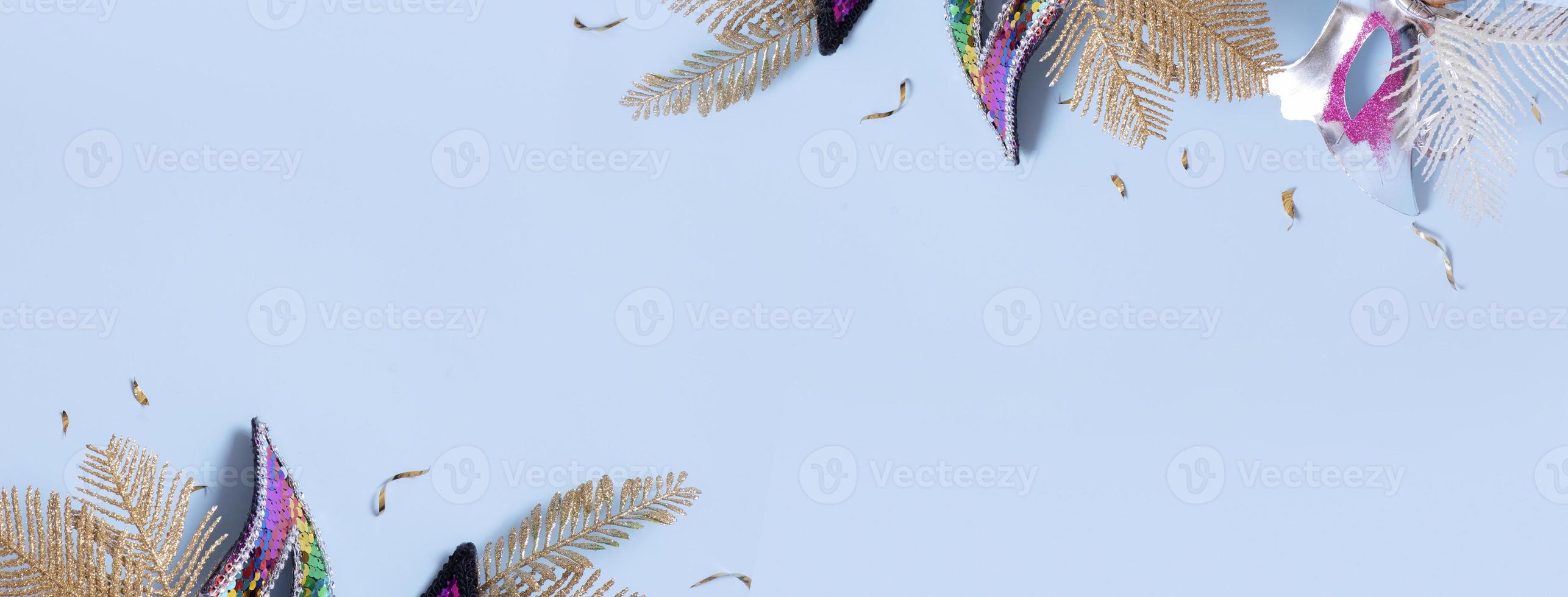 Festive face masks fragments on colored background with copy space. Carnival flat lay banner photo