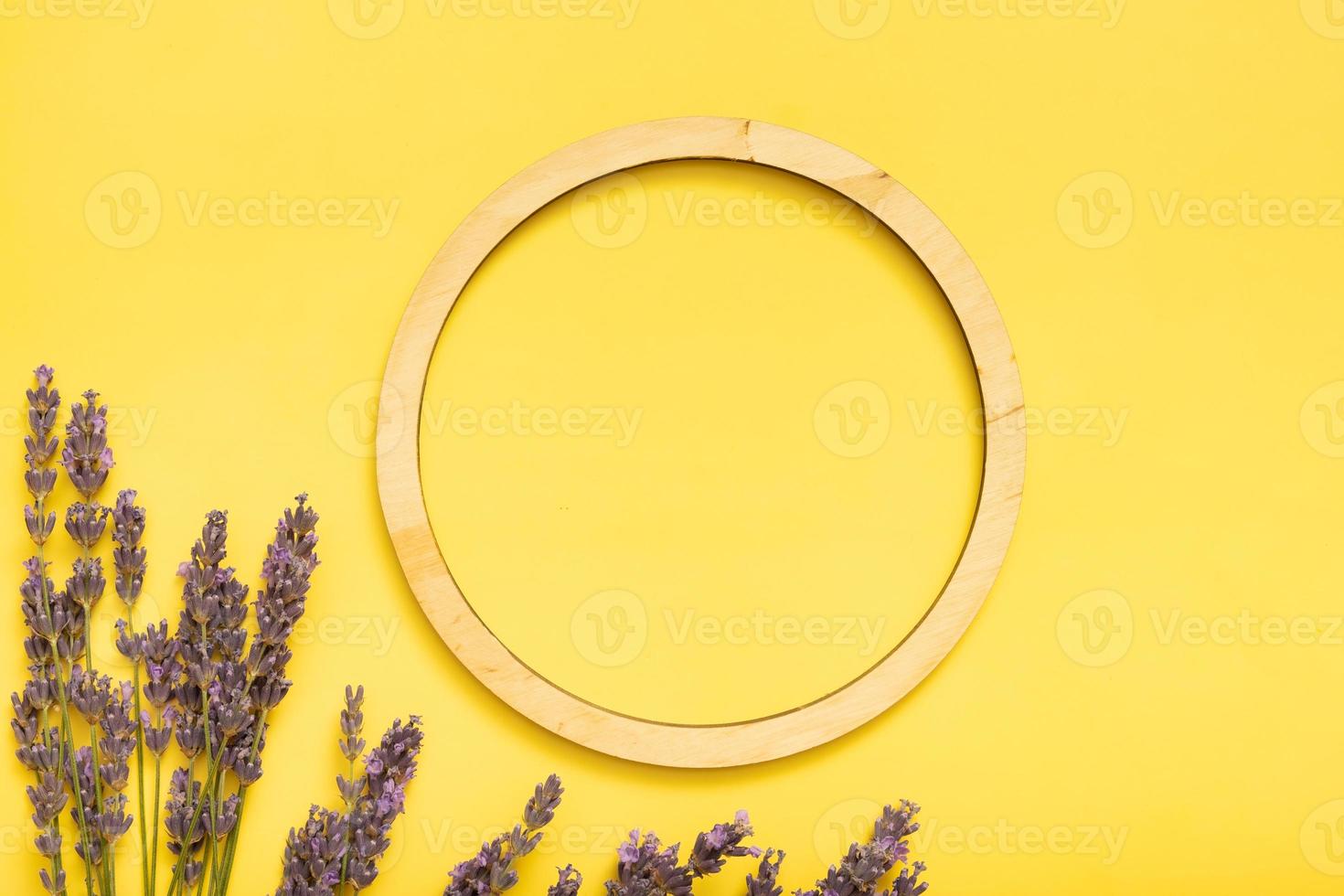 Wooden frame with text space and lavender flowers on colored background top view. Copy space photo