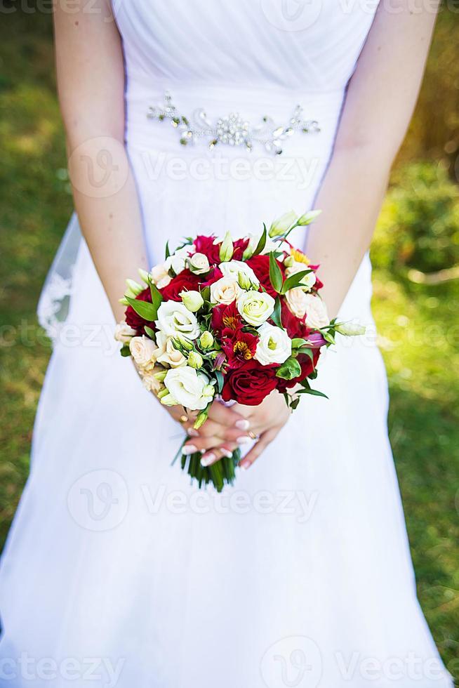 bride in white dress holding a bouquet photo