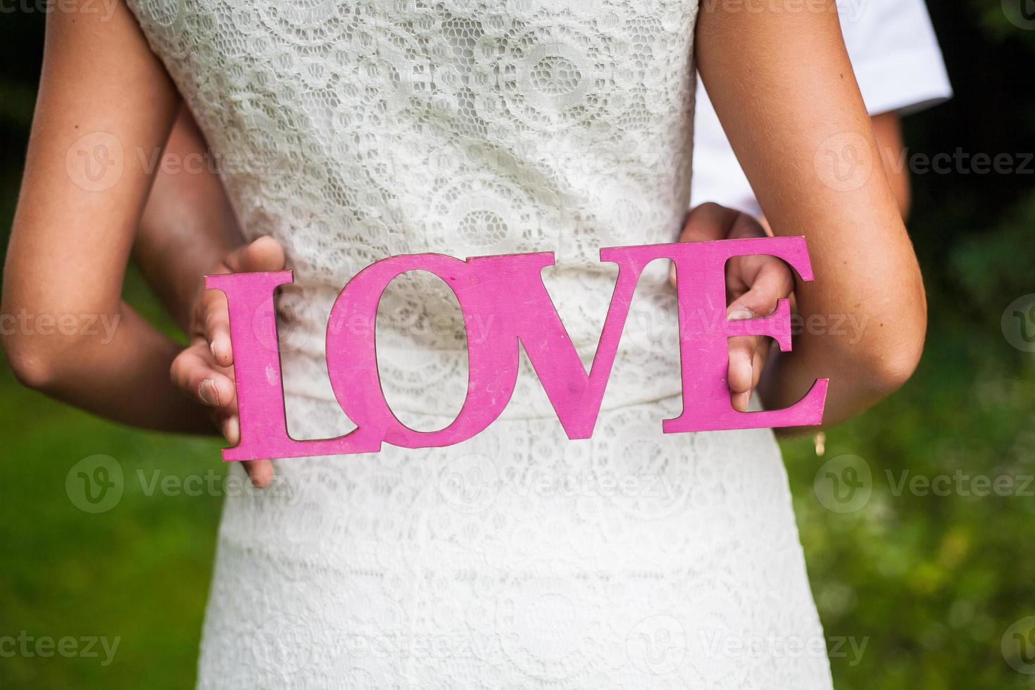 wooden pink love letter in the hands of young photo