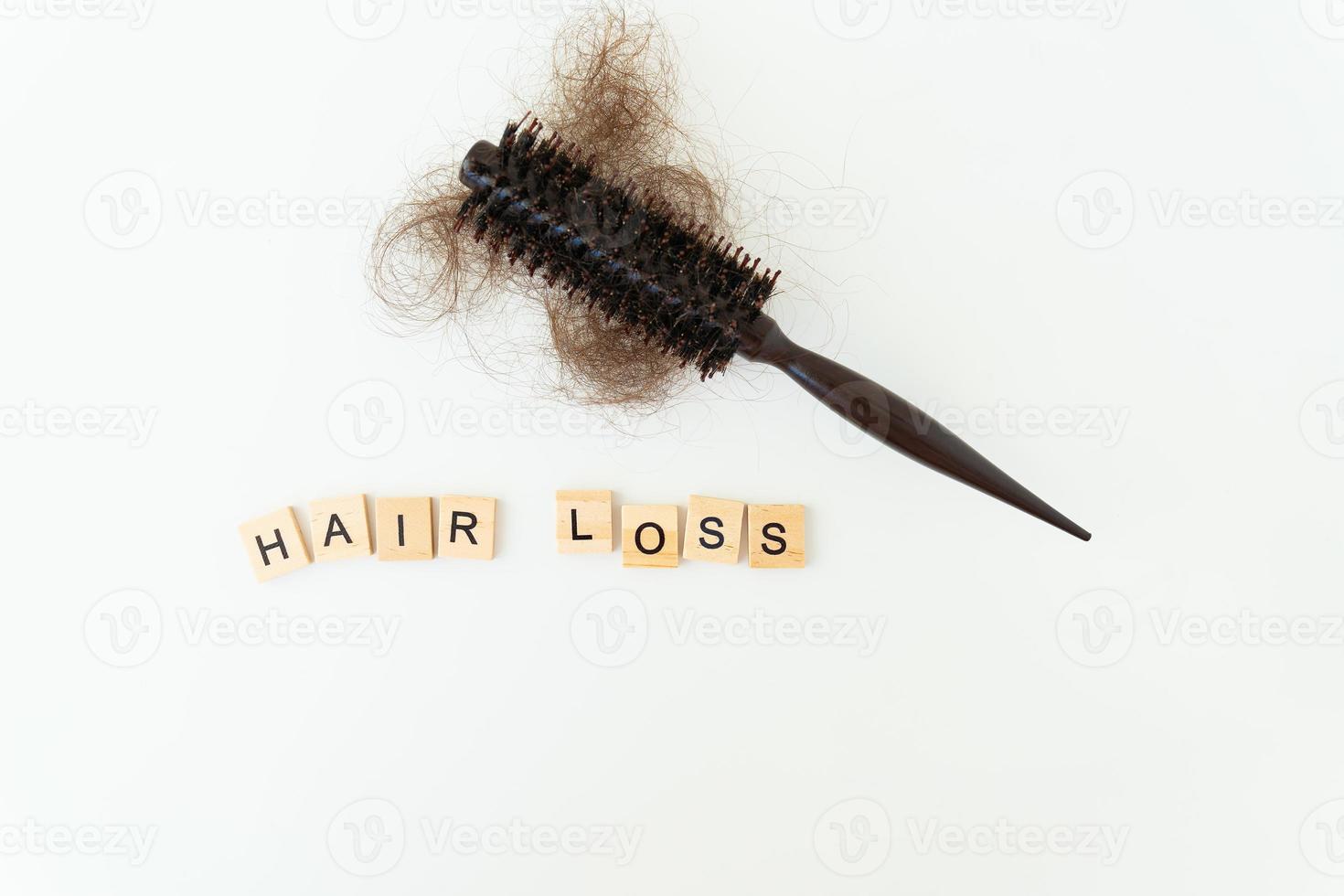 Hair loss in comb, daily serious hair loss problem, on white background. Inscription in wood letters. photo