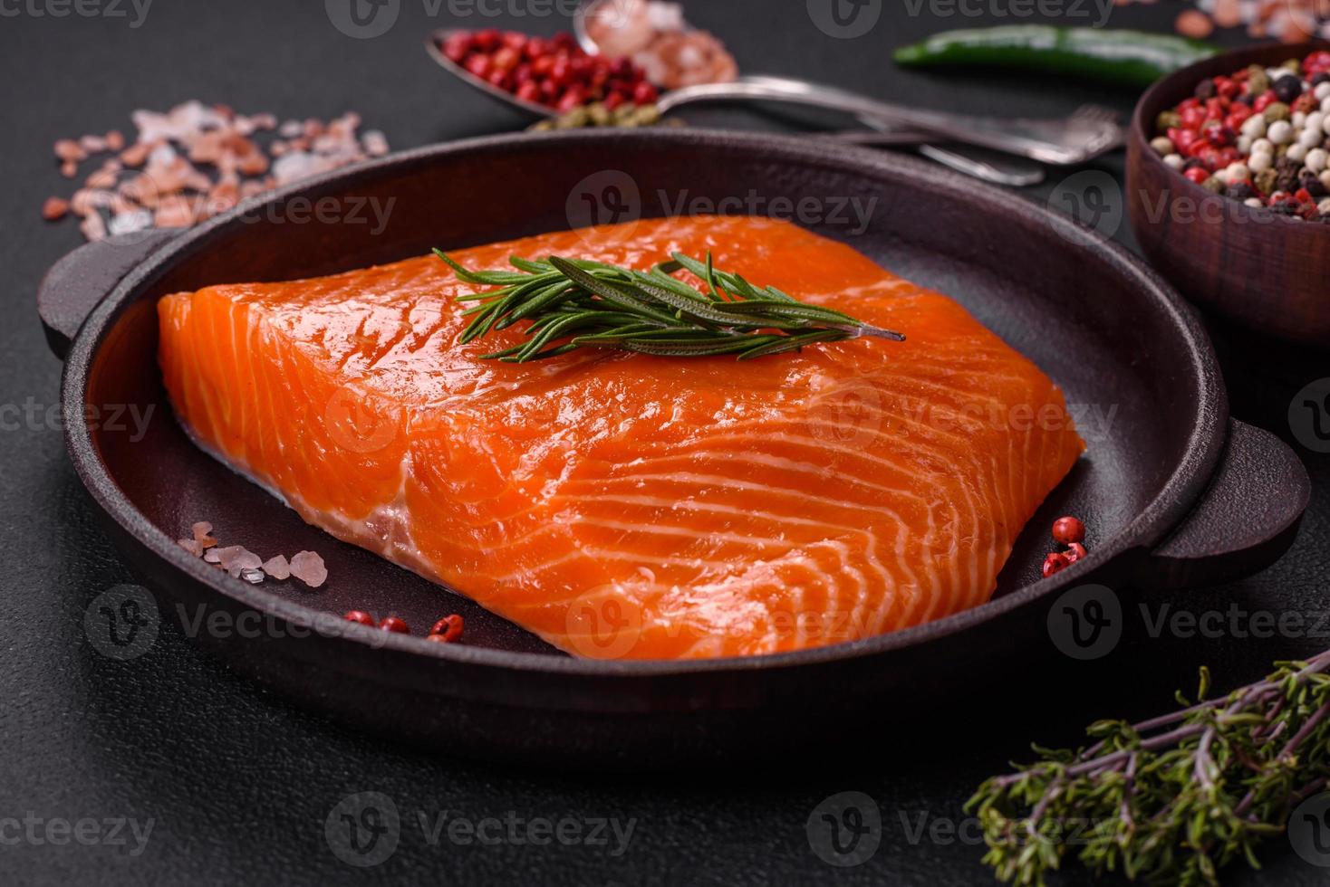 filete de salmón rojo crudo con sal, especias y hierbas foto