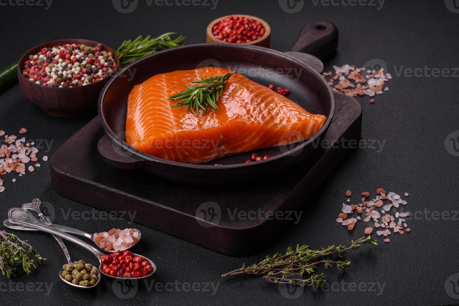 Fillet of raw red salmon fish with salt, spices and herbs photo