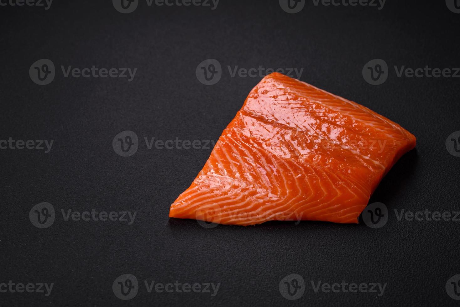 Fillet of raw red salmon fish with salt, spices and herbs photo