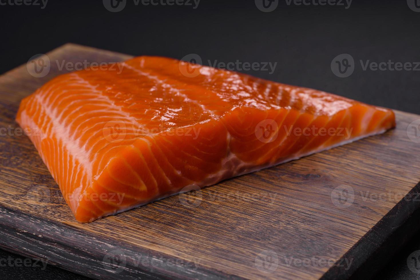 Fillet of raw red salmon fish with salt, spices and herbs photo