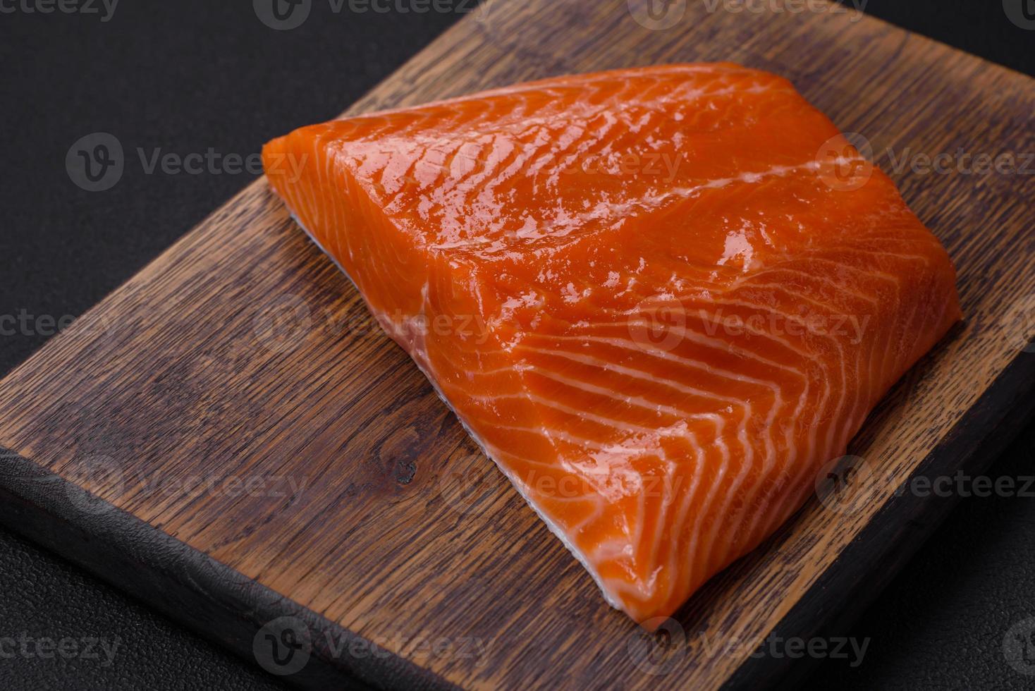 Fillet of raw red salmon fish with salt, spices and herbs photo