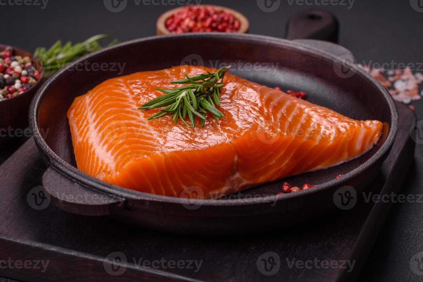 filete de salmón rojo crudo con sal, especias y hierbas foto