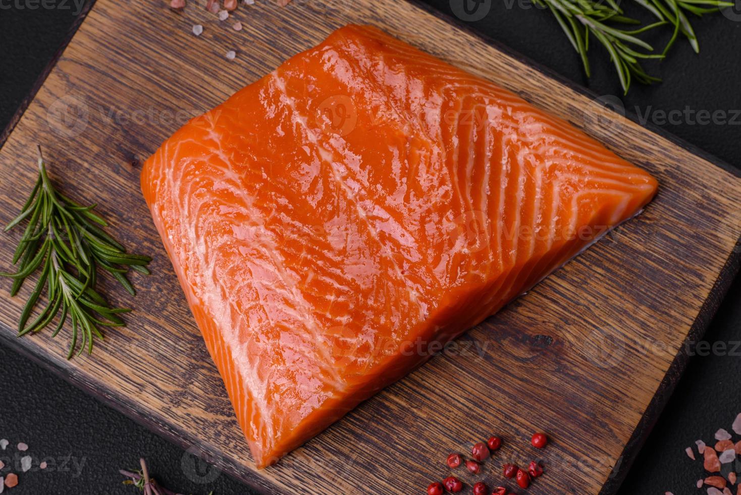 Fillet of raw red salmon fish with salt, spices and herbs photo