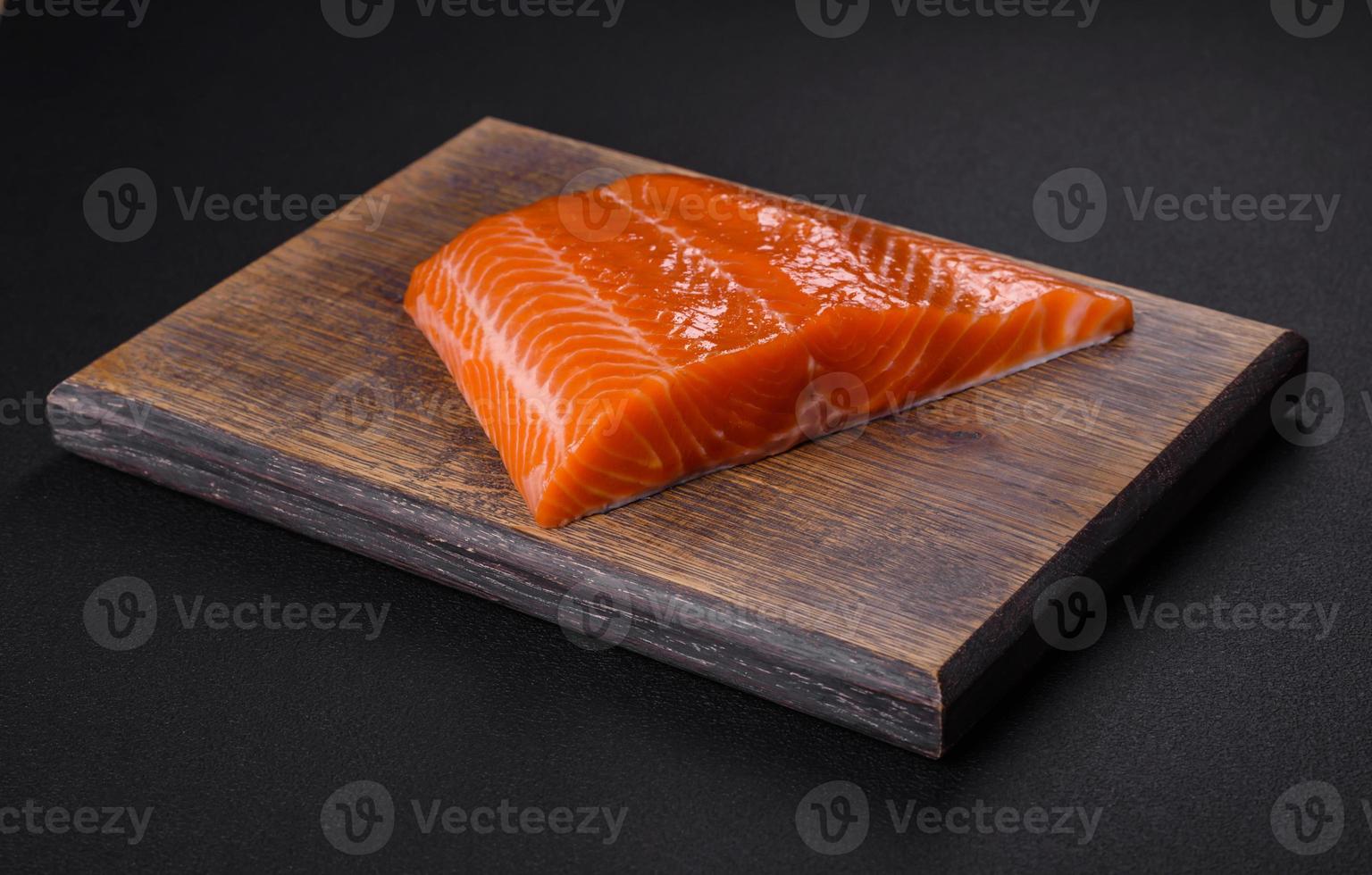 Fillet of raw red salmon fish with salt, spices and herbs photo