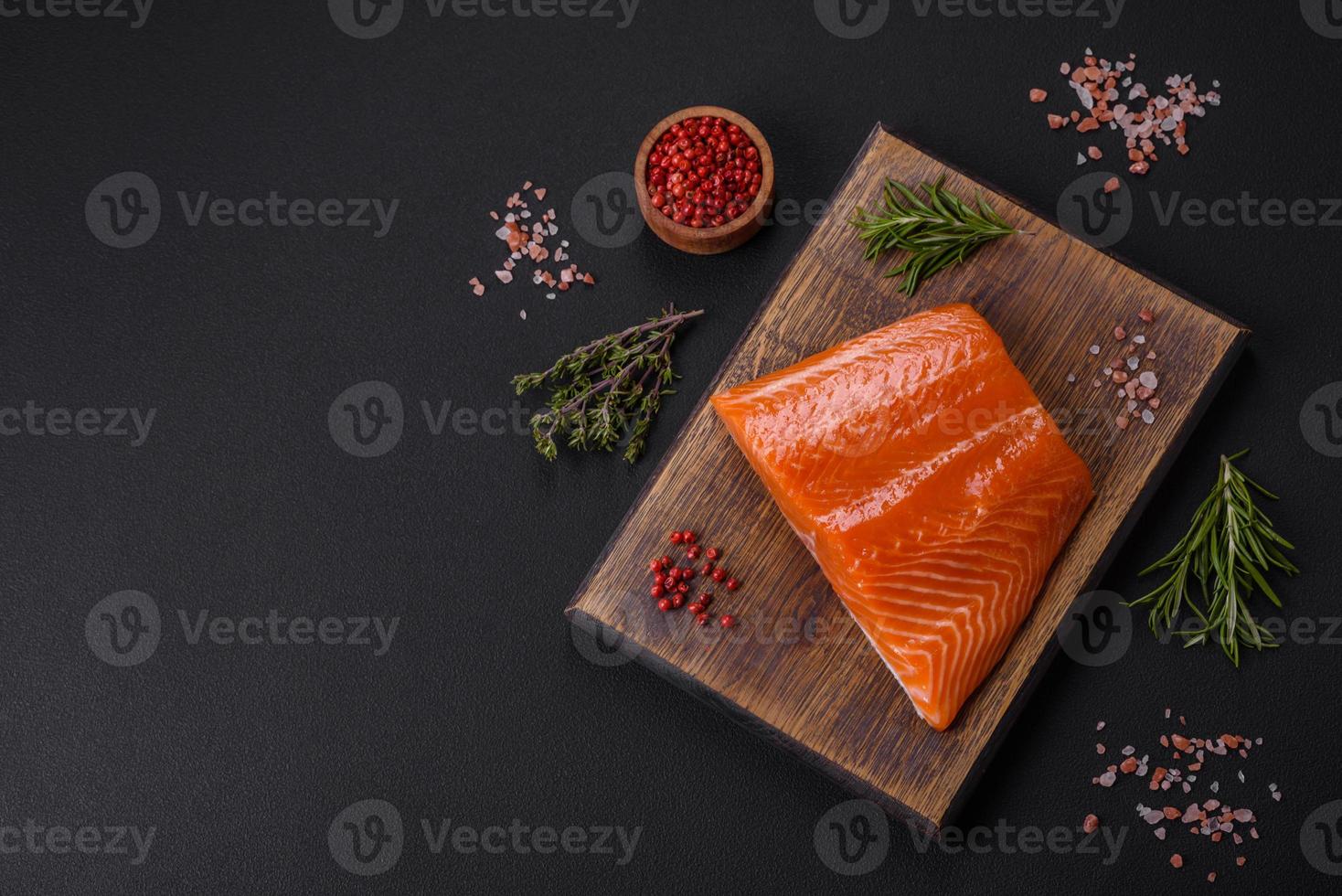 filete de salmón rojo crudo con sal, especias y hierbas foto