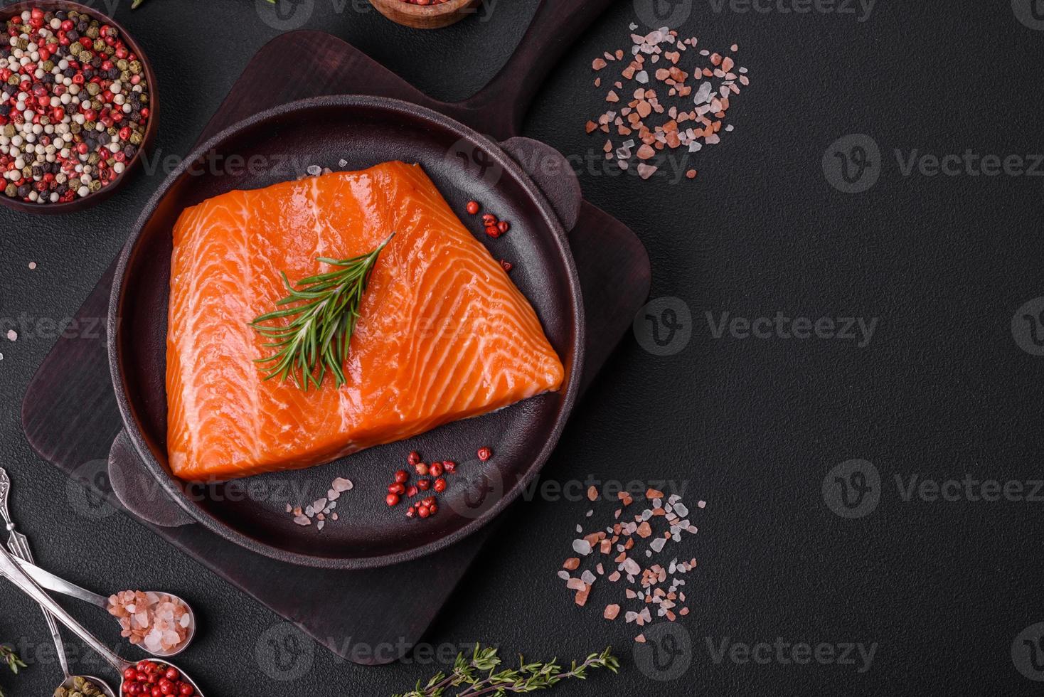 filete de salmón rojo crudo con sal, especias y hierbas foto