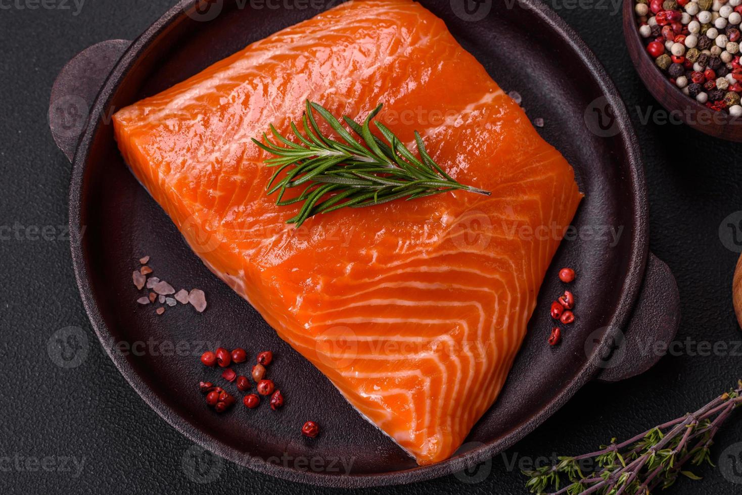 Fillet of raw red salmon fish with salt, spices and herbs photo