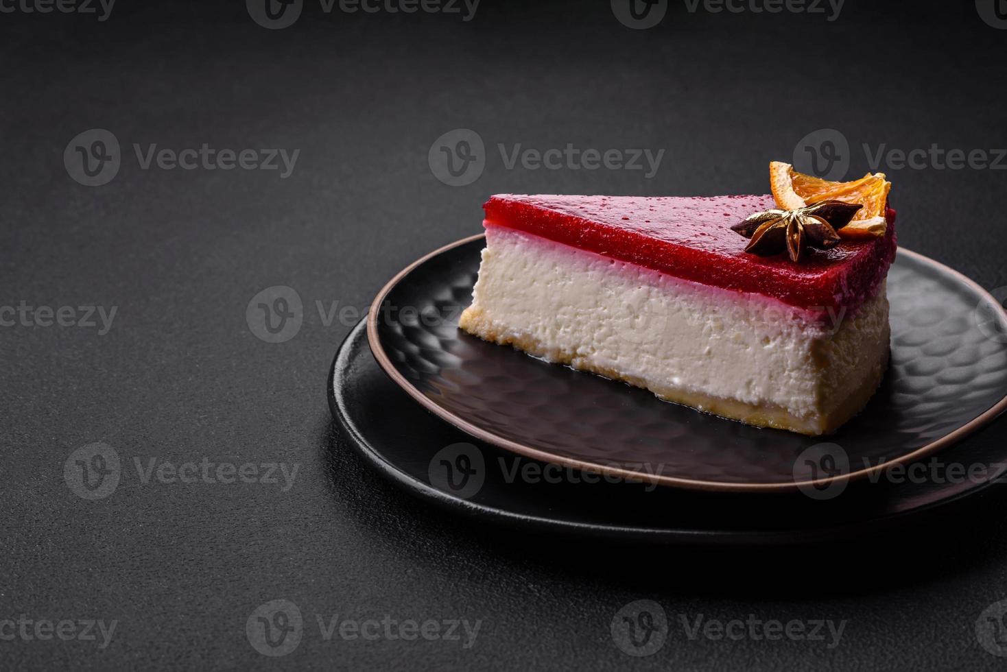 Delicious sweet cheesecake with raspberry jam on a black ceramic plate photo