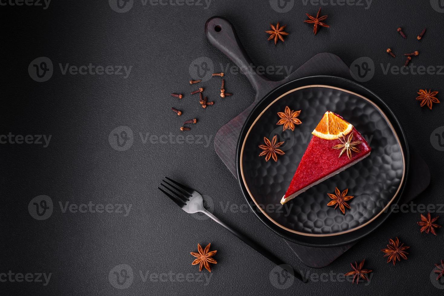 Delicious sweet cheesecake with raspberry jam on a black ceramic plate photo