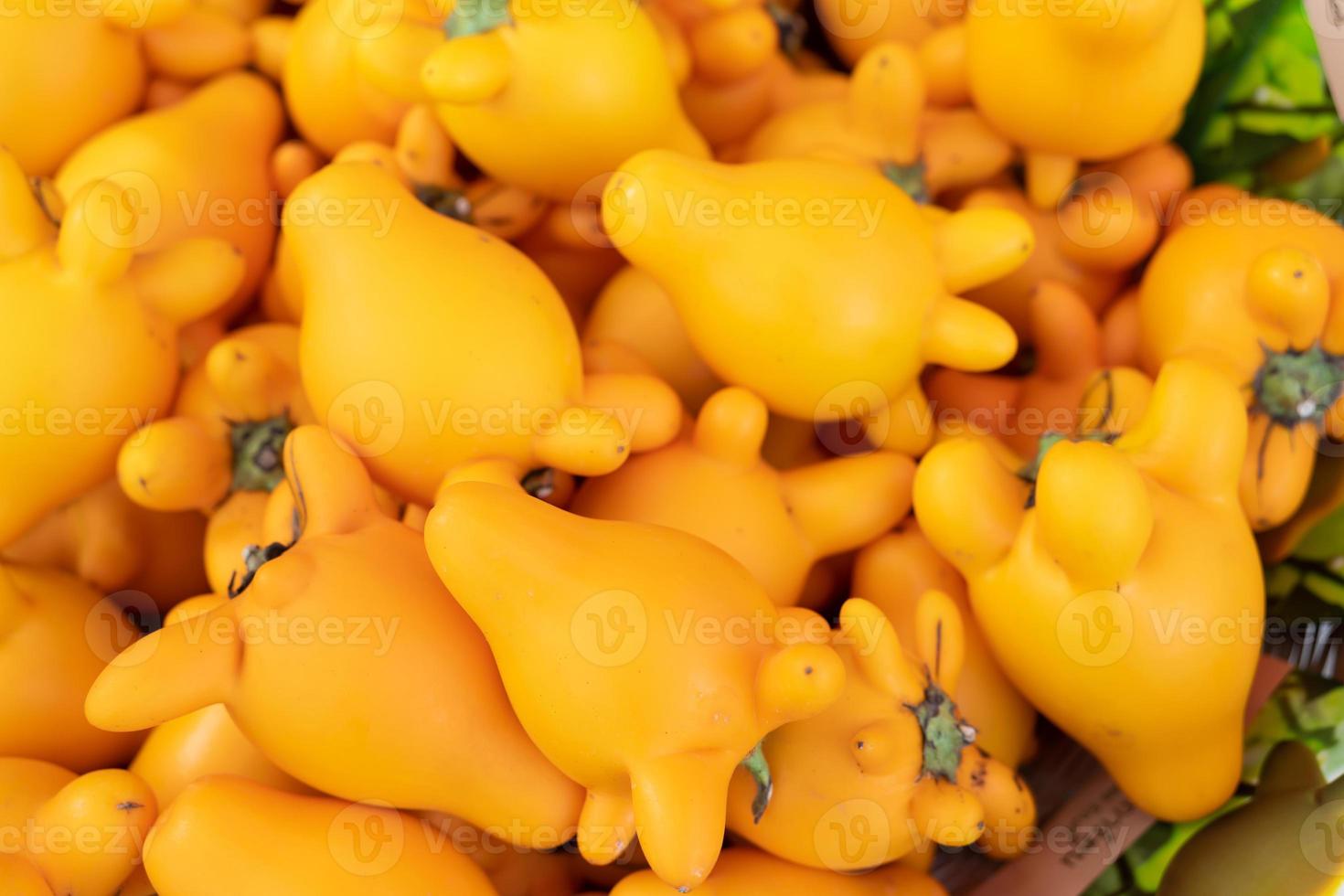 Eggplant cartoon. Yellow eggplants are shaped like a cartoon character with green leaves and spikes. photo