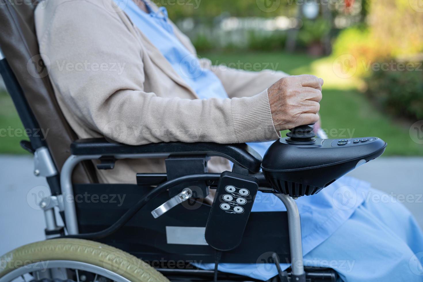 Asian senior or elderly old lady woman patient on electric wheelchair with remote control at nursing hospital ward, healthy strong medical concept photo