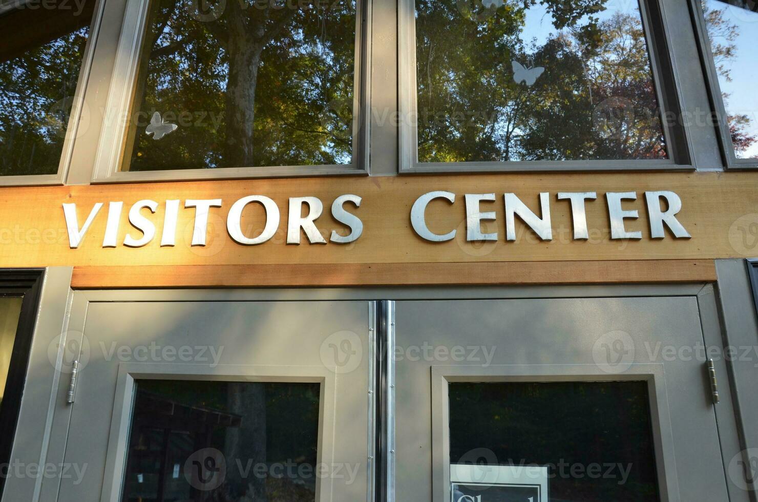 visitors center sign on building with windows and door photo