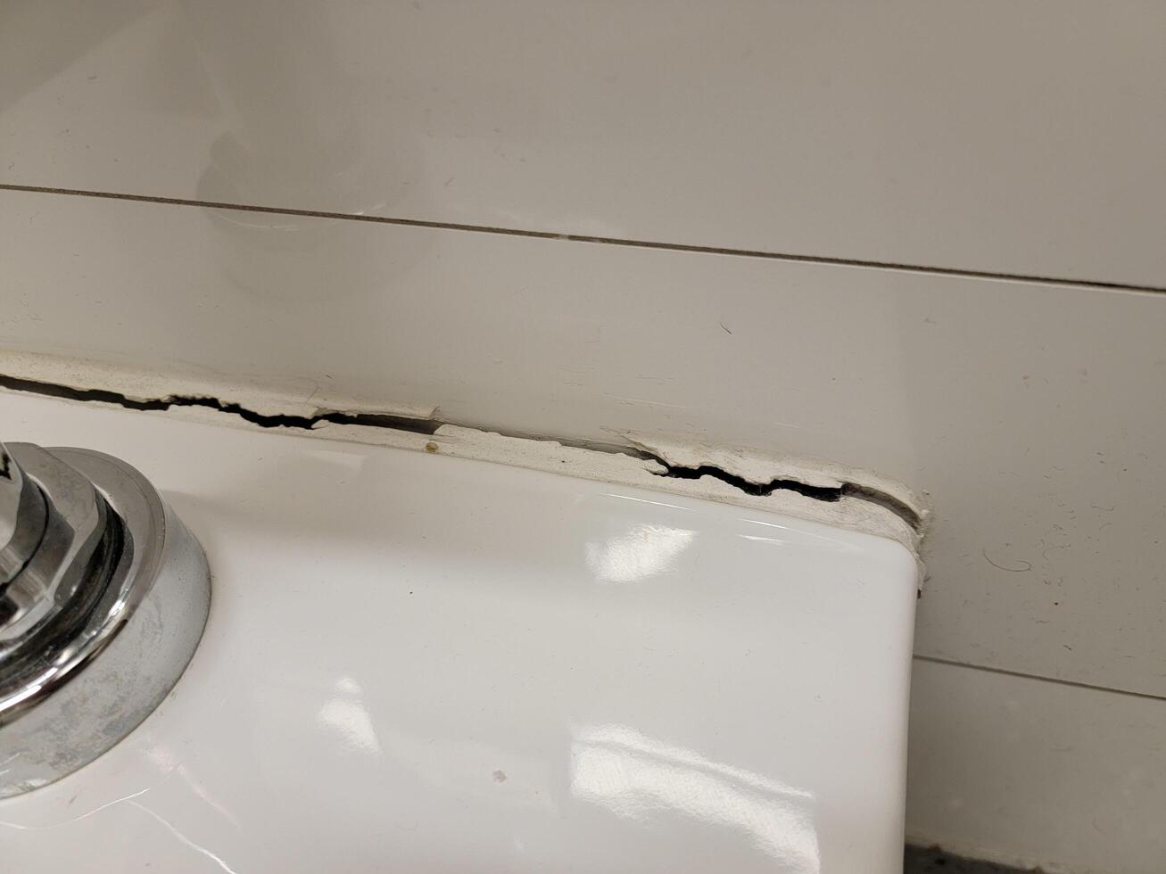 toilet in bathroom with crack in the wall or caulk 17386959 Stock Photo