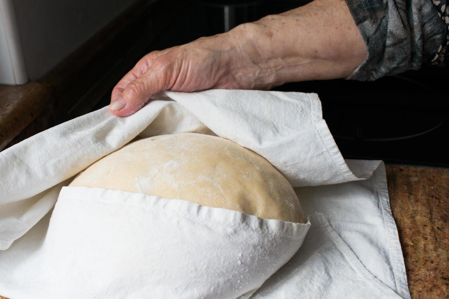 Unrecognizable human hanad checking the casadielles dough during rising photo