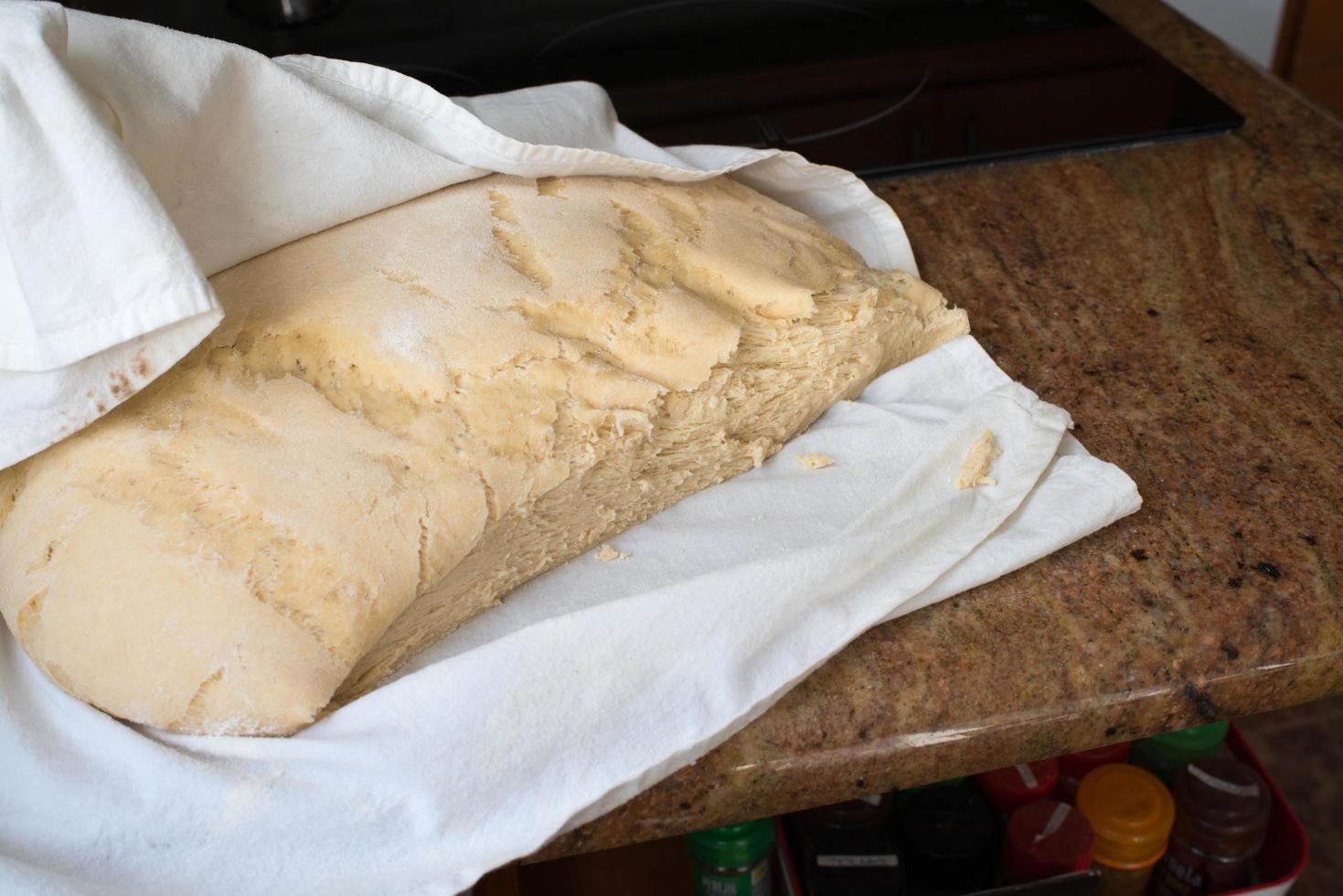 Casadielles dough after rising, protected by a table cloth. photo