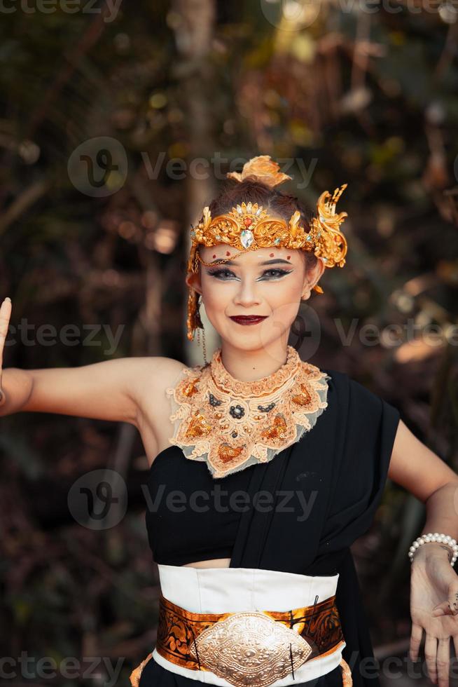 mujer balinesa con una corona de oro y un collar de oro en su maquillaje con una cara hermosa foto