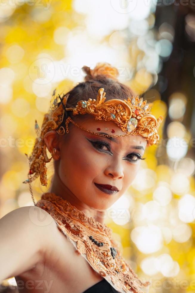 Portrait of Asian woman wearing a gold crown and gold necklace with her gorgeous make-up in black dress photo