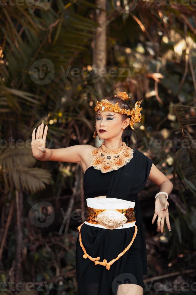 Balinese woman wearing a gold crown and gold necklace in her makeup with a beautiful face photo
