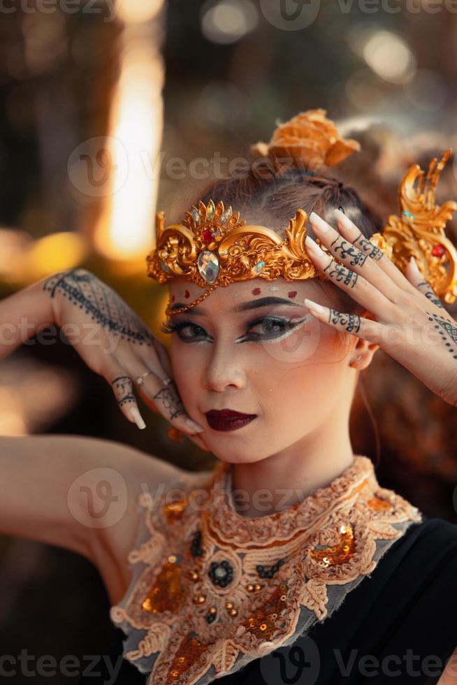 retrato de una reina en su corona dorada y un collar dorado con maquillaje en la cara sonriendo foto