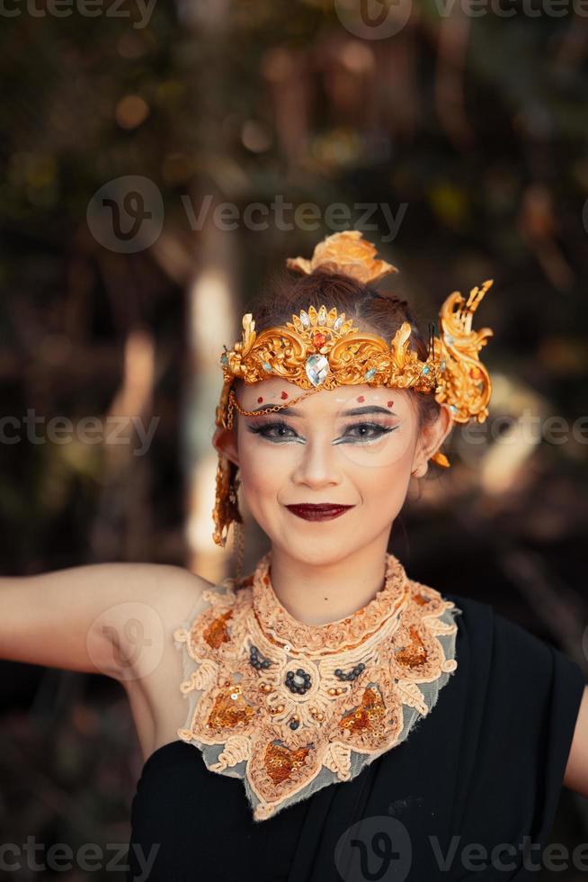 mujer balinesa con una corona de oro y un collar de oro en su maquillaje con una cara hermosa foto