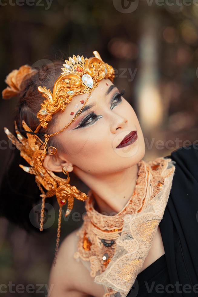 cara de primer plano de una mujer asiática maquillada con corona de oro y accesorios de oro con caras hermosas foto