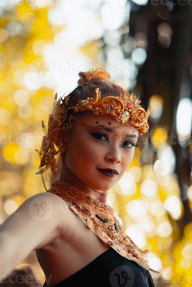 retrato de una mujer asiática con una corona de oro y un collar de oro con su hermoso maquillaje vestido de negro foto