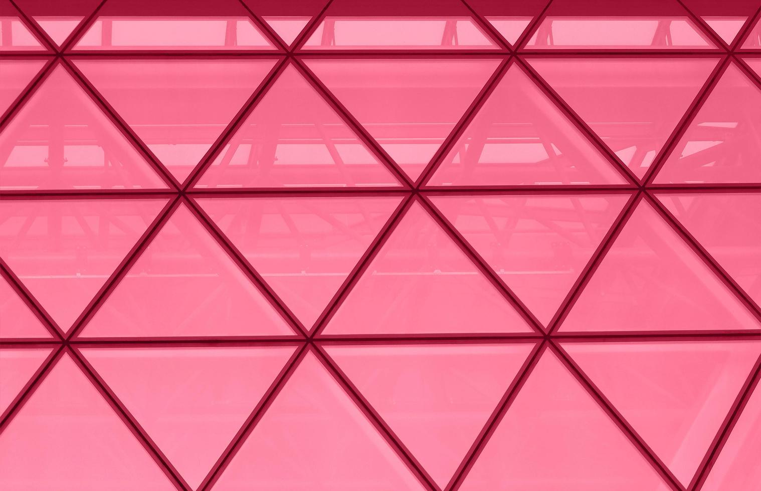 Office building facade with triangular windows, modern skyscraper toned into Viva Magenta color. Inspired by Pantone color of the year 2023. Horizontal photo with place for text.