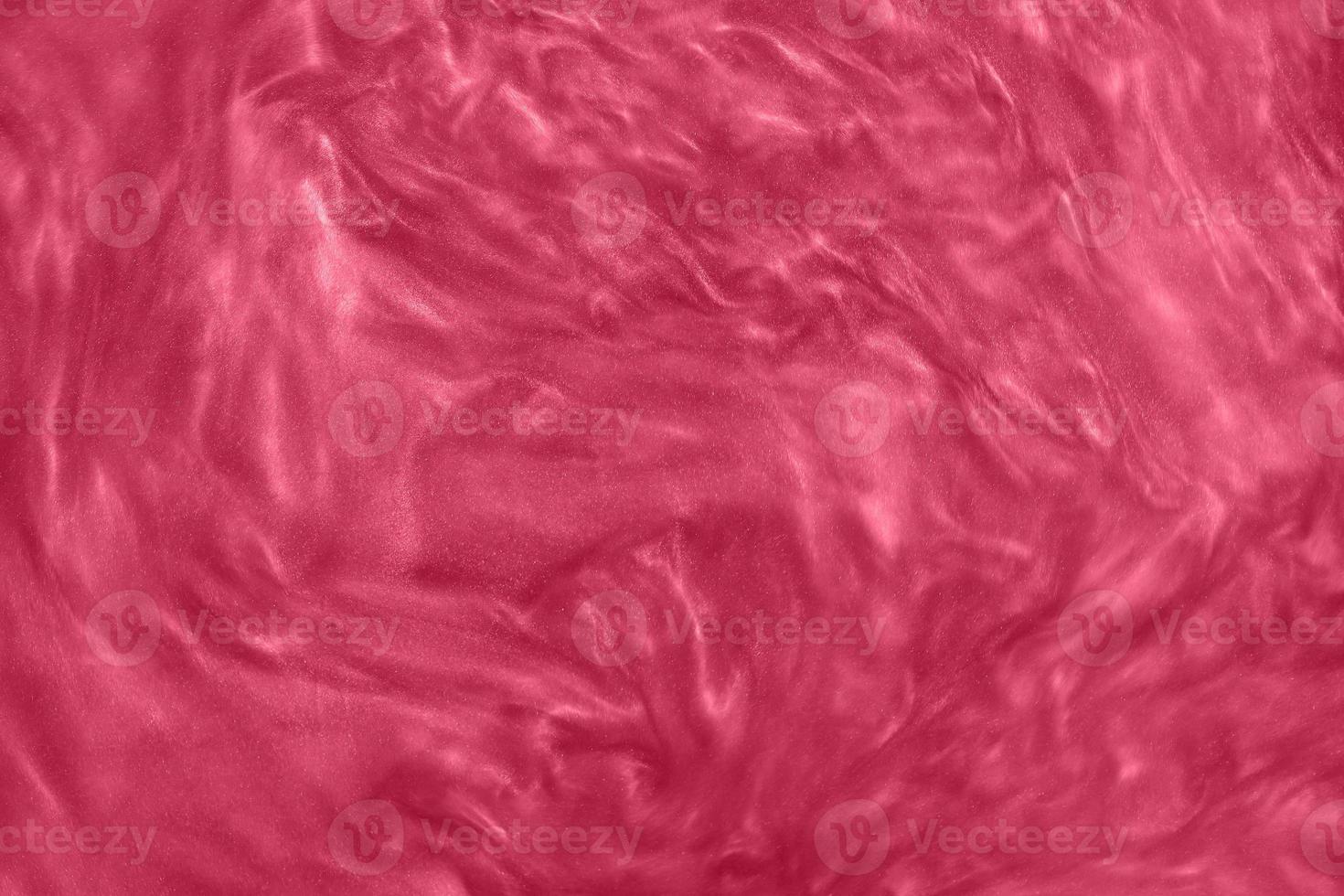 Abstract pink-red liquid paint gradient background toned into Viva Magenta color. Inspired by Pantone color of the year 2023. Glittering nail polish red maroon textured pattern. photo