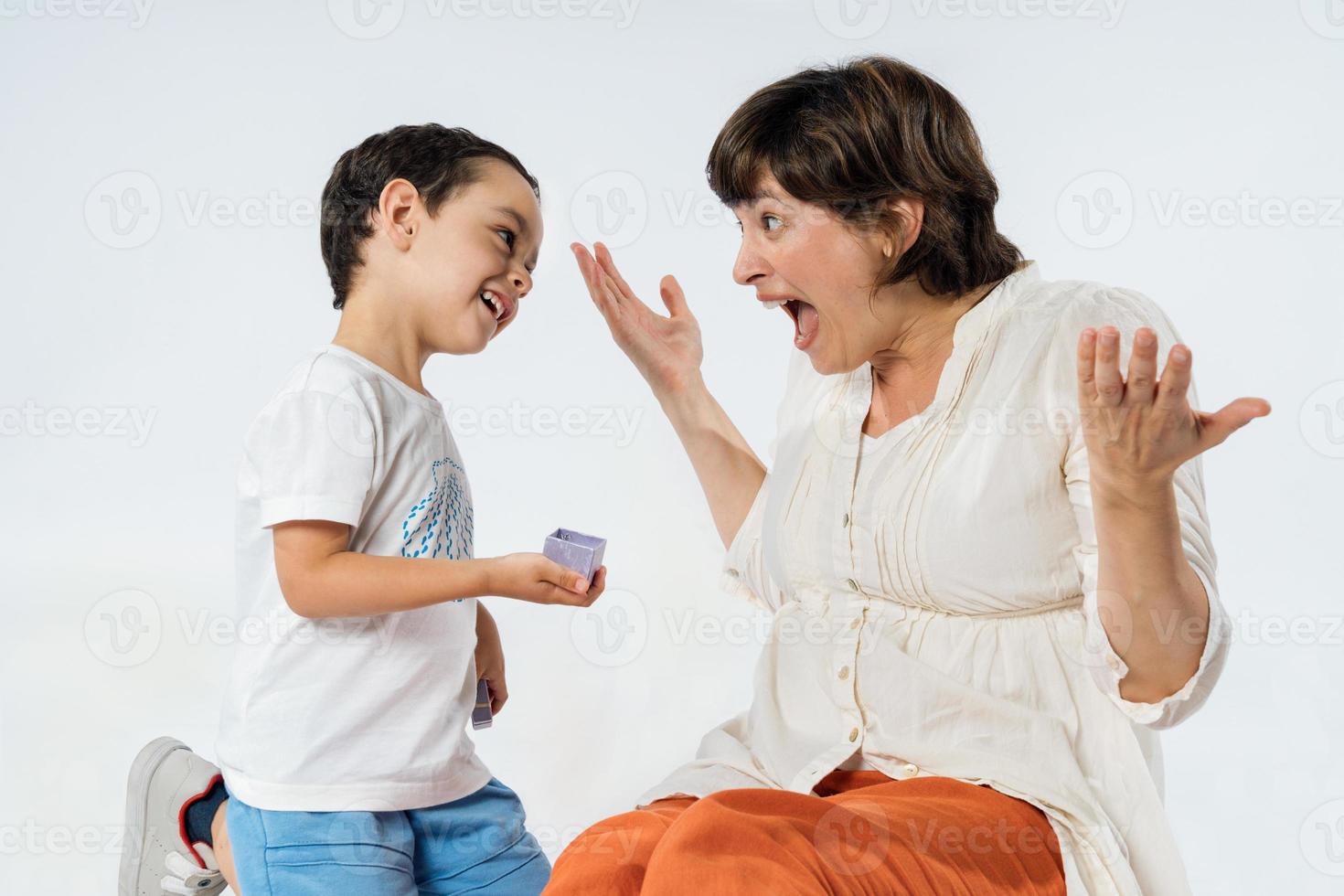 A little boy surprises his mother with a gift. photo