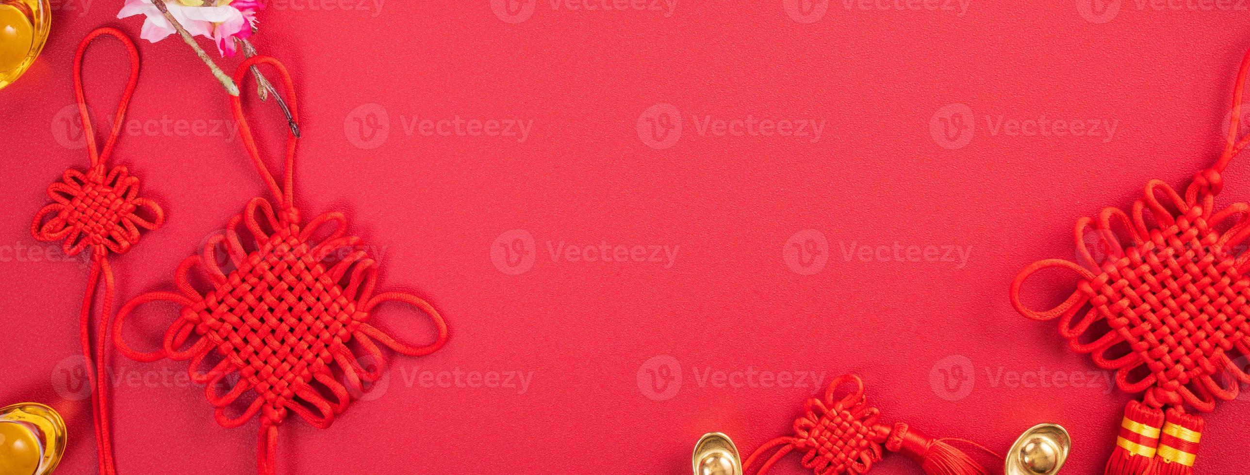 Design concept of Chinese lunar new year - Beautiful Chinese knot with plum blossom isolated on red background, flat lay, top view, overhead layout. photo