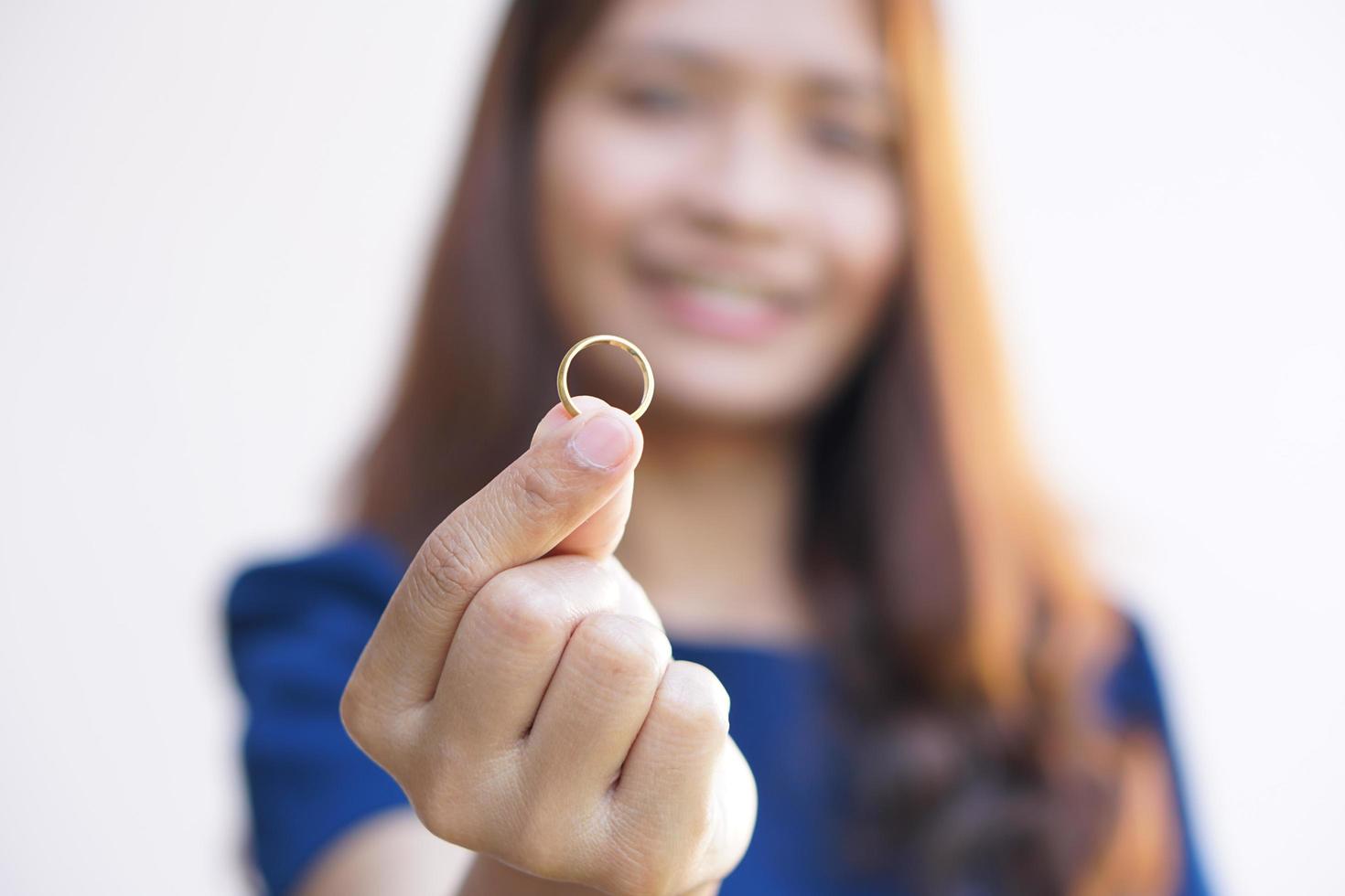 Happy asian woman looking at wedding ring photo