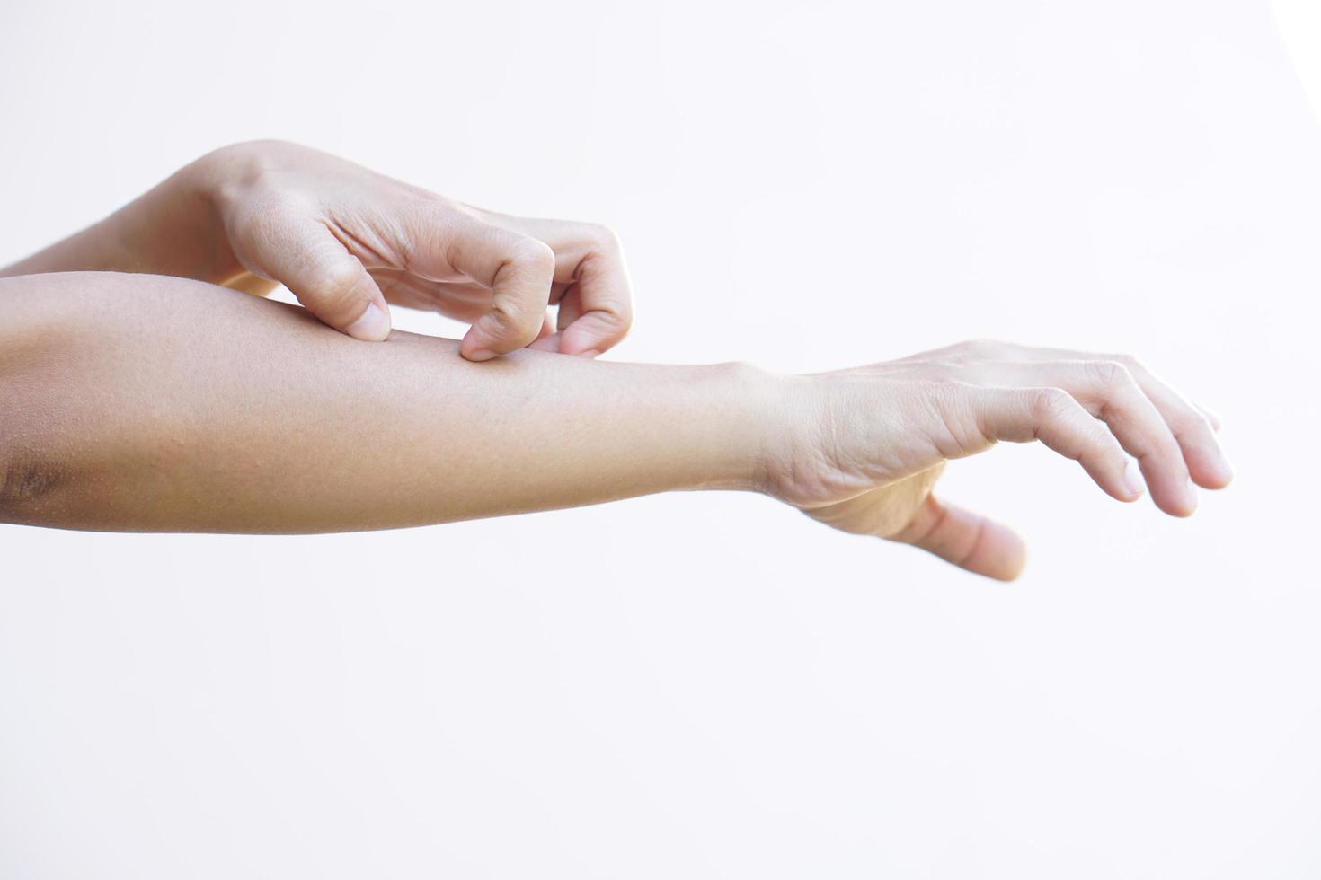 Woman scratching arm from itching on light gray background. Cause of itchy skin include insect bites Concept of health care skin. photo