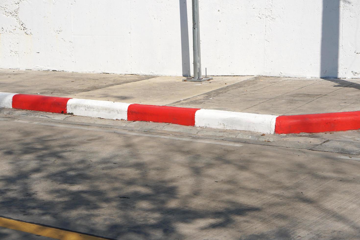 Red and white stripes on the side of the road for no parking. photo