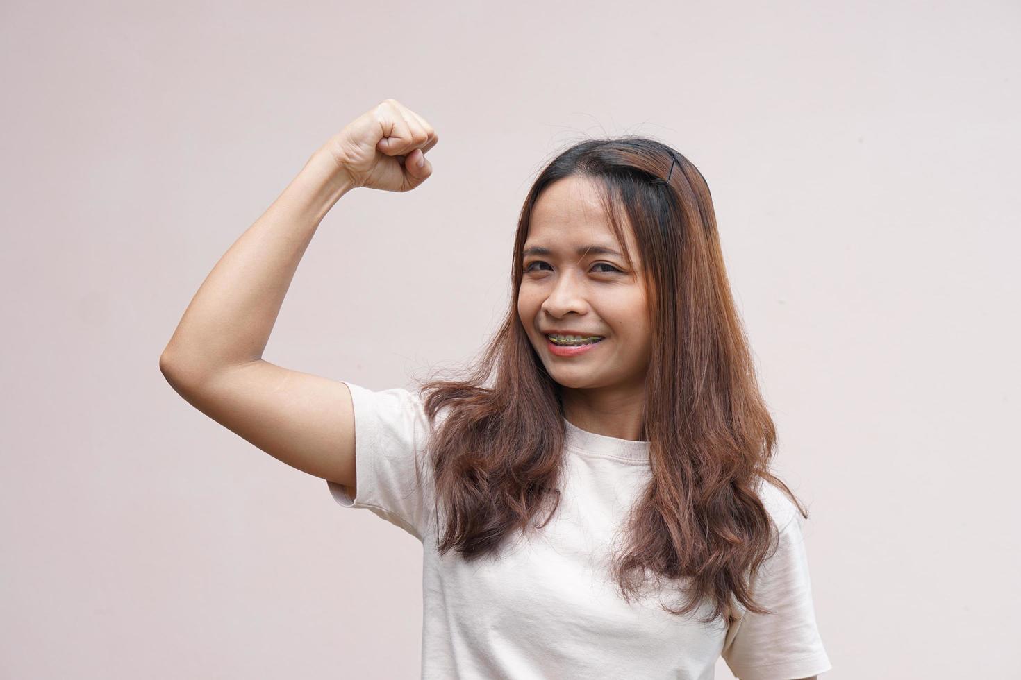 las mujeres asiáticas flexionan sus músculos y muestran su fuerza. foto