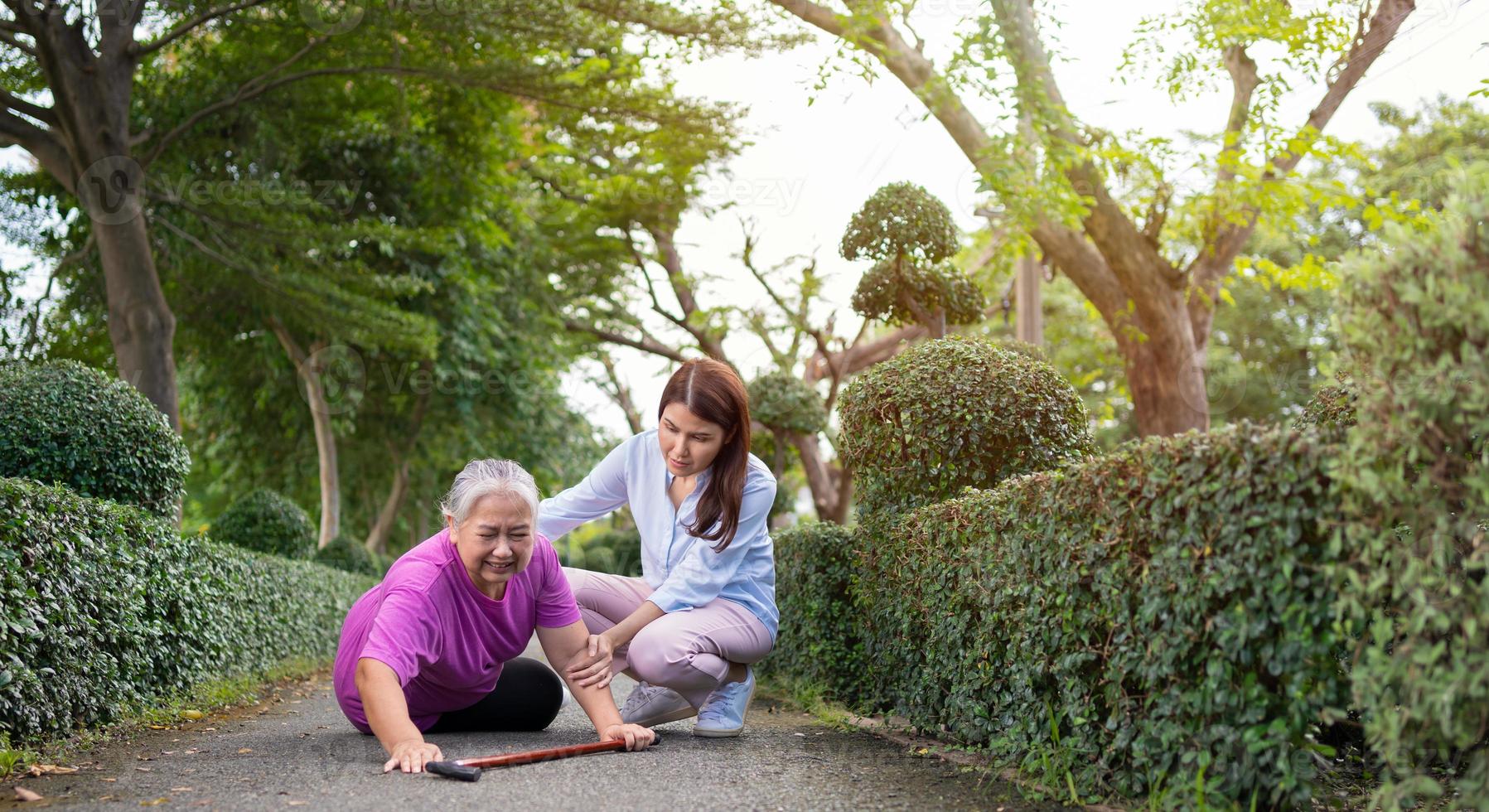 Asian senior woman fell down on lying floor because faint and limb weakness and Crying in pain form accident and her daughter came to help support. Concept of old elderly insurance and health care photo