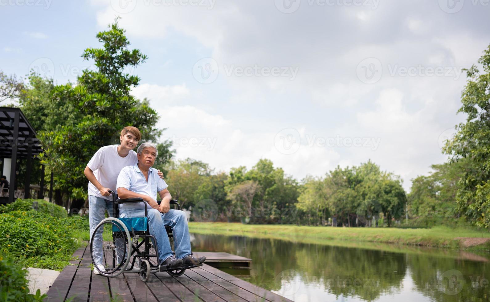 Asian careful caregiver or nurse hold the patient hand and encourage the patient in a wheelchair. Concept of happy retirement with care from a caregiver and Savings and senior health insurance. photo