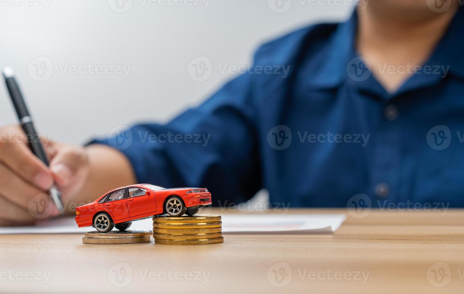 Unhappy Asian man holding a banknote and Making an account of income and expenses to pay the home loan and car loan, Concept loan payment and home insurance, economic problems, and inflation photo