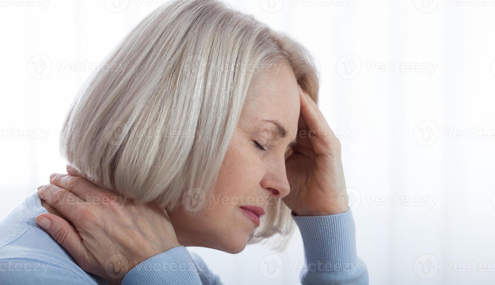 Concept coronavirus, covid-19 respiratory virus with indicating location of the pain.Woman suffering from stress or a headache grimacing in pain as she holds the back of her neck photo