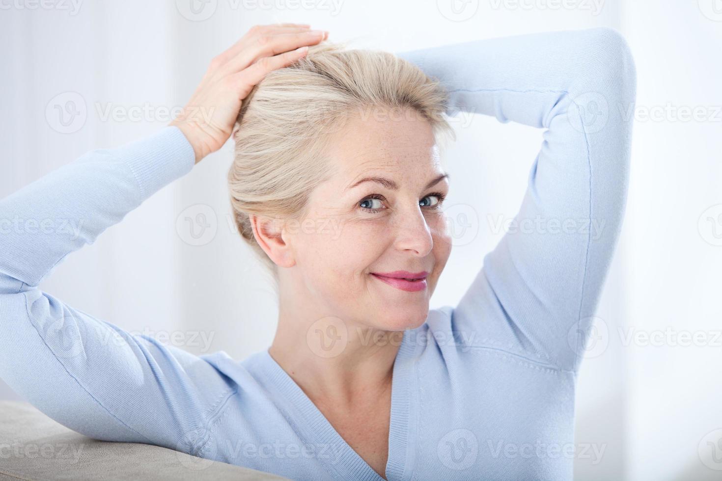 activa hermosa mujer de mediana edad sonriendo amable y mirando a la cámara. primer plano de la cara de la mujer. imágenes realistas sin retoques con sus propias imperfecciones. enfoque selectivo. foto