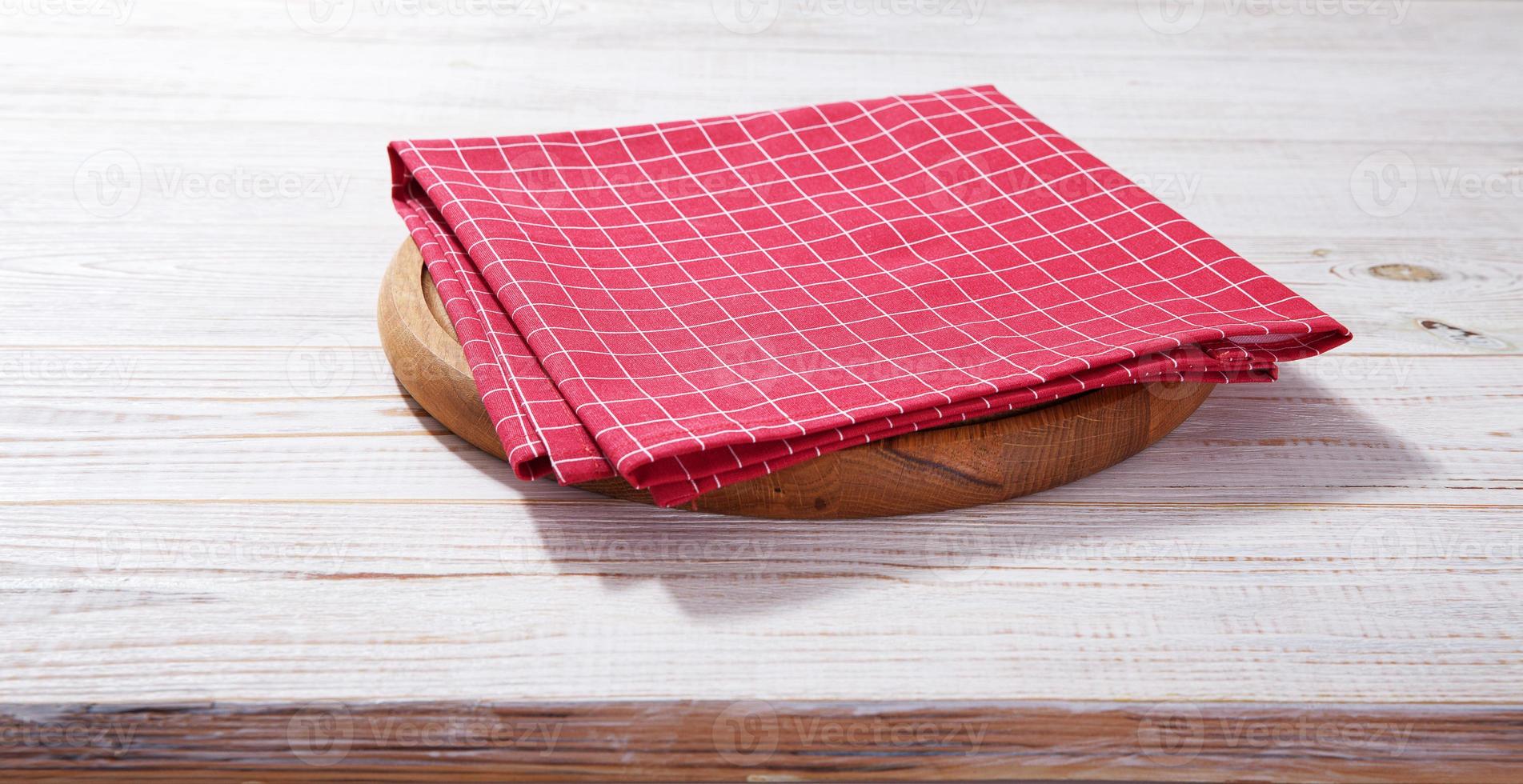 Empty pizza board and red napkin on white wooden photo