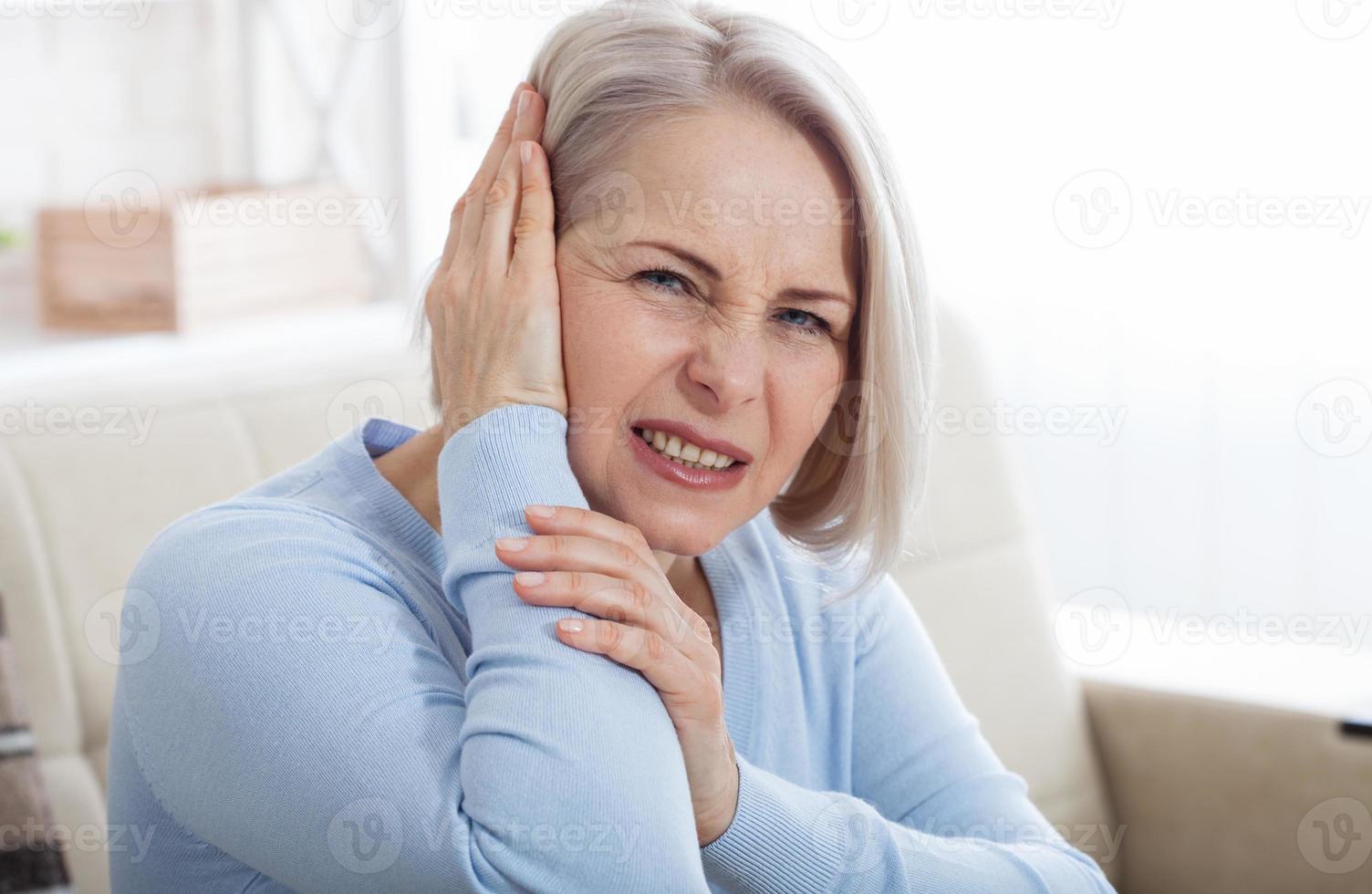 Tinnitus. Closeup up side profile sick female having ear pain touching