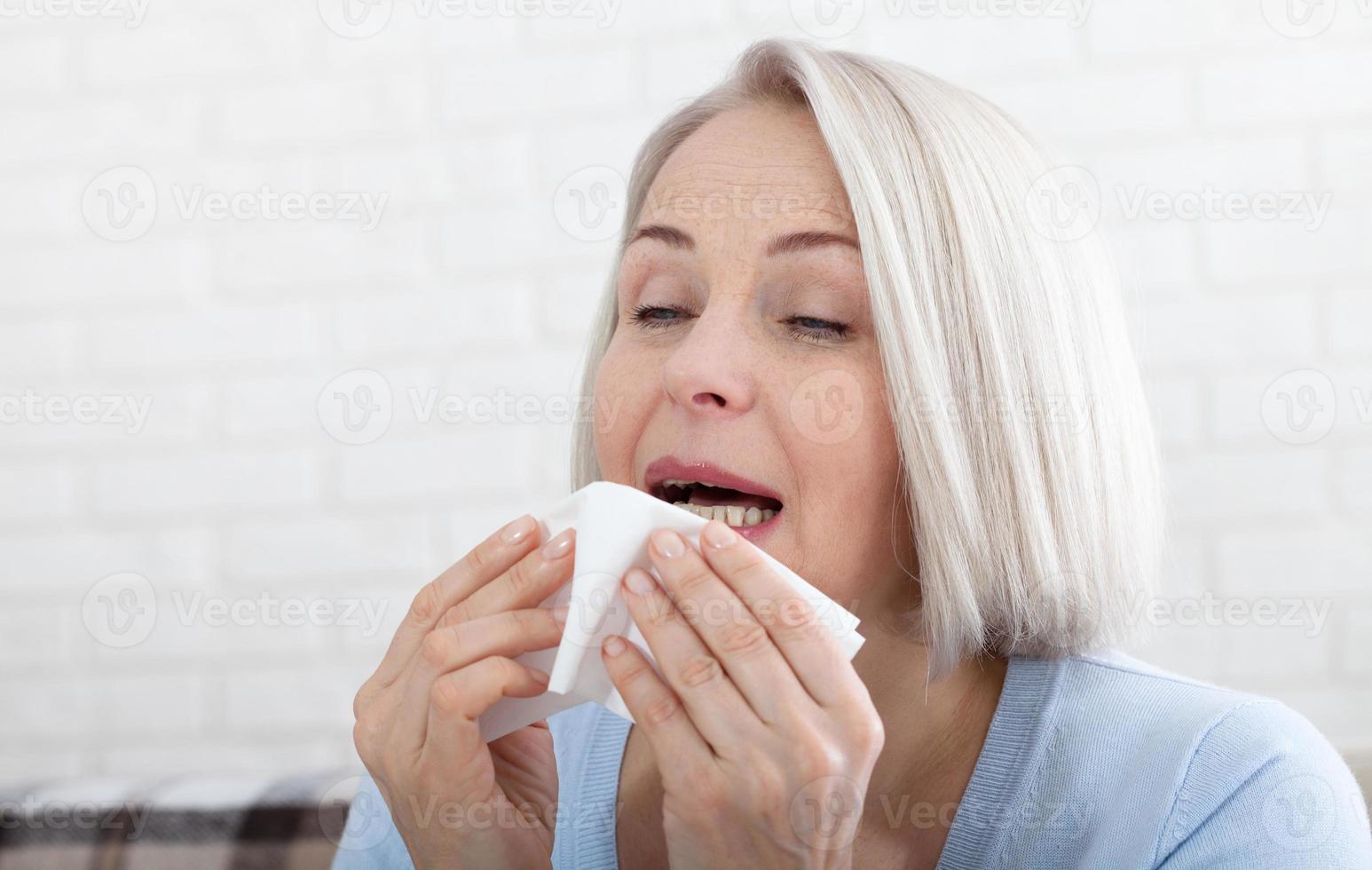 Concept coronavirus, covid-19 respiratory virus with indicating location of the pain. Healthcare, cold, allergy and sick woman blowing her runny nose in paper tissue. photo