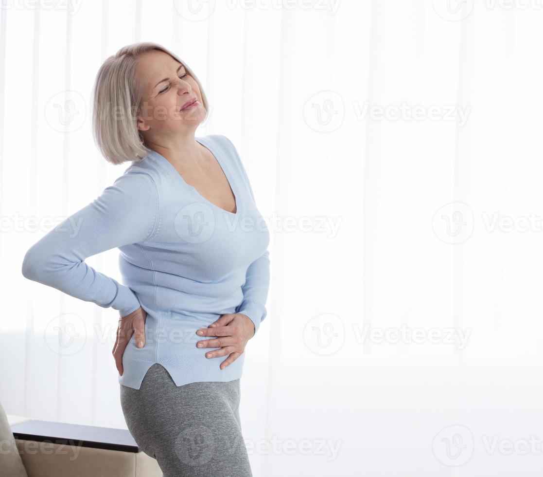 Woman in pain holding her stomach on the right side photo