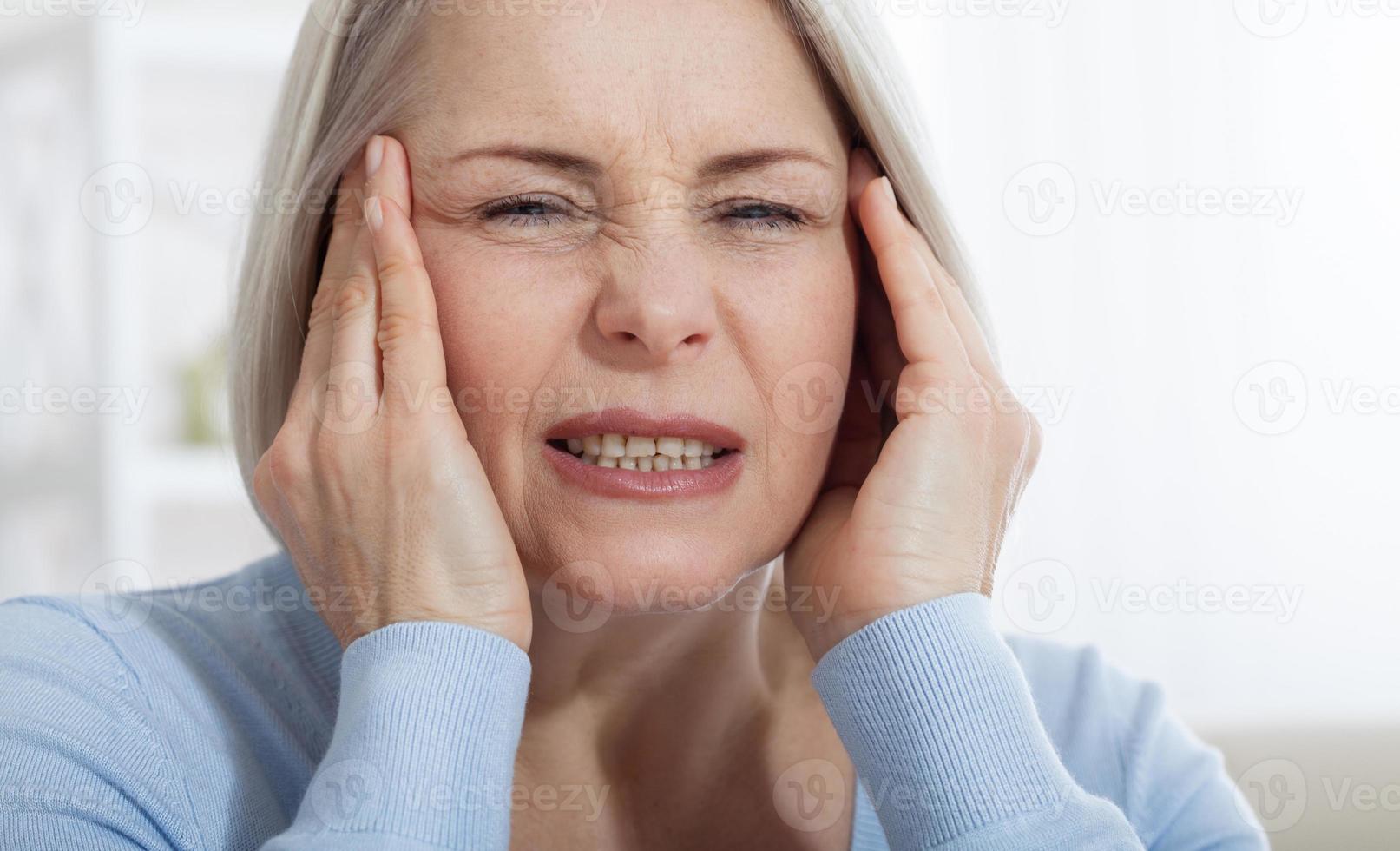 Concept coronavirus, covid-19 respiratory virus with indicating location of the pain.Woman suffering from stress or a headache grimacing in pain as she holds the back of her neck photo