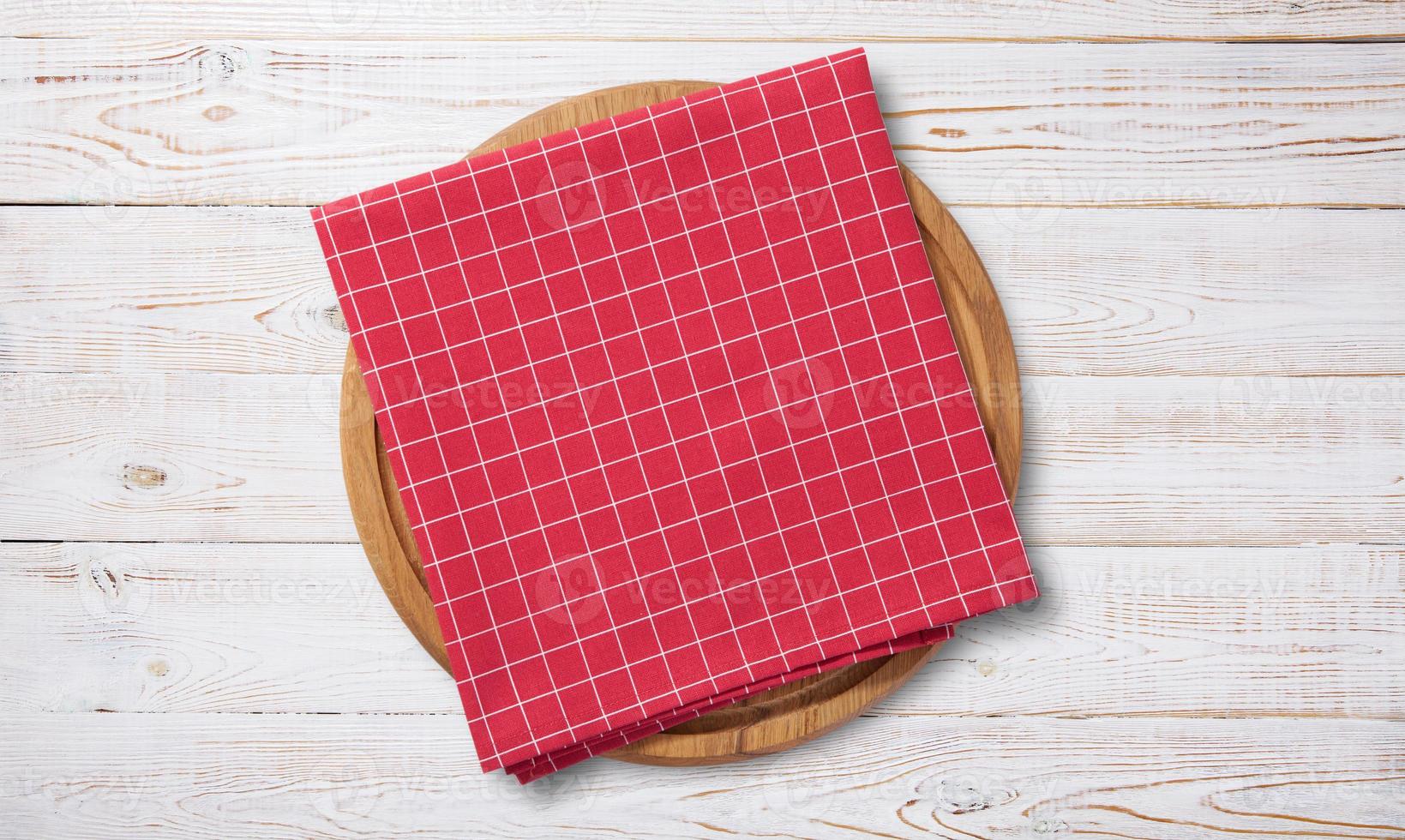 Empty pizza board and red napkin on white wooden photo